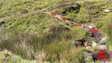 A photo of step 10 of the Axe Edge Walk route, with red arrows superimposed to show the way.
