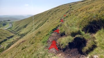 A photo of step 12 of the Axe Edge Walk route, with red arrows superimposed to show the way.
