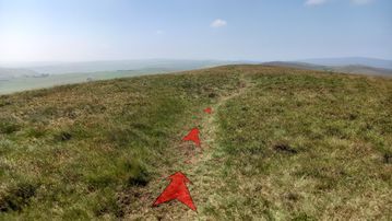 A photo of step 14 of the Axe Edge Walk route, with red arrows superimposed to show the way.