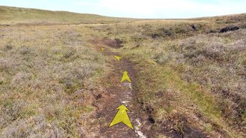 A photo of step 21 of the Axe Edge Walk route, with yellow arrows superimposed to show the way.