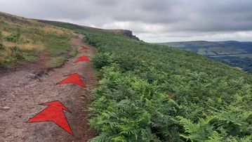 A photo of step 10 of the Bamford Edge Walk route, with red arrows superimposed to show the way.