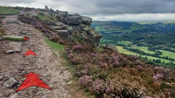 A photo of step 11 of the Bamford Edge Walk route, with red arrows superimposed to show the way.