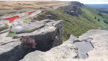 A photo of step 12 of the Bamford Edge Walk route, with red arrows superimposed to show the way.