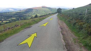 A photo of step 19 of the Bamford Edge Walk route, with yellow arrows superimposed to show the way.