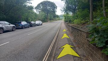 A photo of step 23 of the Bamford Edge Walk route, with yellow arrows superimposed to show the way.