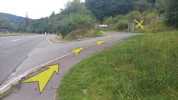 A photo of step 24 of the Bamford Edge Walk route, with yellow arrows superimposed to show the way.