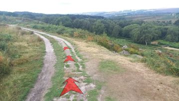 A photo of step 11 of the Burbage Rocks & Higger Tor Walk route, with red arrows superimposed to show the way.