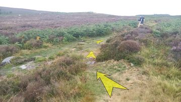 A photo of step 22 of the Burbage Rocks & Higger Tor Walk route, with yellow arrows superimposed to show the way.