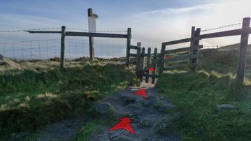 A photo of step 4 of the Cats Tor Walk route, with red arrows superimposed to show the way.