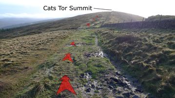 A photo of step 6 of the Cats Tor Walk route, with red arrows superimposed to show the way.