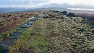 A photo of step 7 of the Cats Tor Walk route, with red arrows superimposed to show the way.