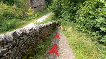A photo of step 5 of the Chee Dale Walk route, with red arrows superimposed to show the way.