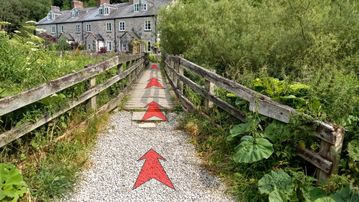 A photo of step 6 of the Chee Dale Walk route, with red arrows superimposed to show the way.