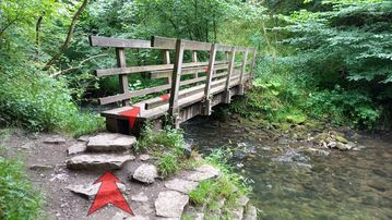 A photo of step 13 of the Chee Dale Walk route, with red arrows superimposed to show the way.