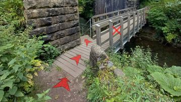 A photo of step 8 of the Chee Dale Walk route, with red arrows superimposed to show the way.