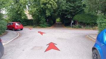 A photo of step 3 of the Corbar Hill Walk route, with red arrows superimposed to show the way.