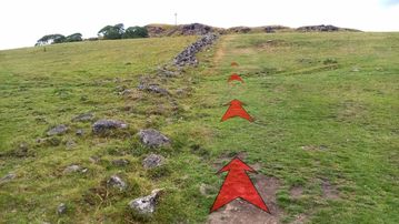 A photo of step 15 of the Corbar Hill Walk route, with red arrows superimposed to show the way.