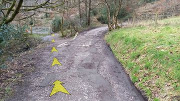 A photo of step 12 of the Fernilee Reservoir Walk route, with yellow arrows superimposed to show the way.