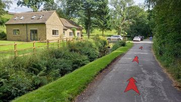 A photo of step 3 of the Kinder Reservoir Walk route, with red arrows superimposed to show the way.