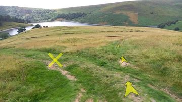 A photo of step 16 of the Kinder Reservoir Walk route, with yellow arrows superimposed to show the way.
