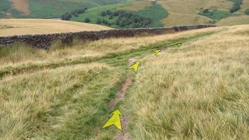 A photo of step 17 of the Kinder Reservoir Walk route, with yellow arrows superimposed to show the way.