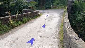 A photo of step 35 of the Kinder Reservoir Walk route, with blue arrows superimposed to show the way.