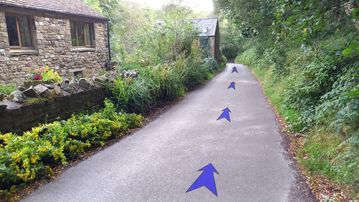 A photo of step 36 of the Kinder Reservoir Walk route, with blue arrows superimposed to show the way.