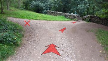 A photo of step 6 of the Lud's Church Walk route, with red arrows superimposed to show the way.