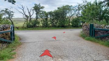 A photo of step 1 of the Shutlingsloe Walk route, with red arrows superimposed to show the way.