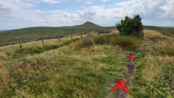 A photo of step 9 of the Shutlingsloe Walk route, with red arrows superimposed to show the way.
