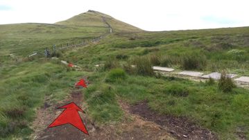A photo of step 14 of the Shutlingsloe Walk route, with red arrows superimposed to show the way.