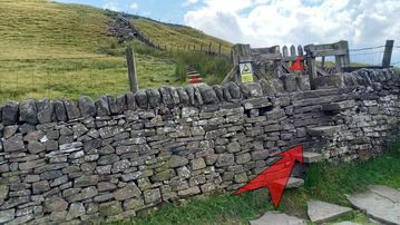 A photo of step 16 of the Shutlingsloe Walk route, with red arrows superimposed to show the way.