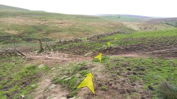 A photo of step 17 of the Three Shires Head Walk route, with yellow arrows superimposed to show the way.