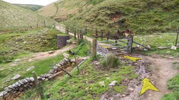 A photo of step 19 of the Three Shires Head Walk route, with yellow arrows superimposed to show the way.