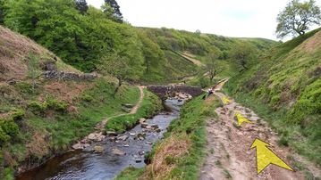 A photo of step 20 of the Three Shires Head Walk route, with yellow arrows superimposed to show the way.