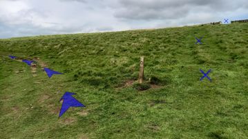 A photo of step 24 of the Three Shires Head Walk route, with blue arrows superimposed to show the way.