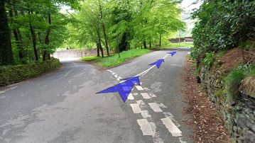 A photo of step 32 of the Three Shires Head Walk route, with blue arrows superimposed to show the way.
