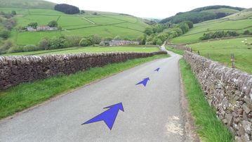 A photo of step 33 of the Three Shires Head Walk route, with blue arrows superimposed to show the way.