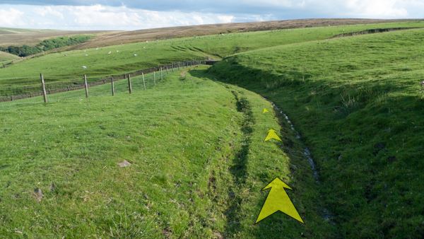 A photo of step 3 of the Three Shires Head route, with yellow arrows superimposed to show the way.