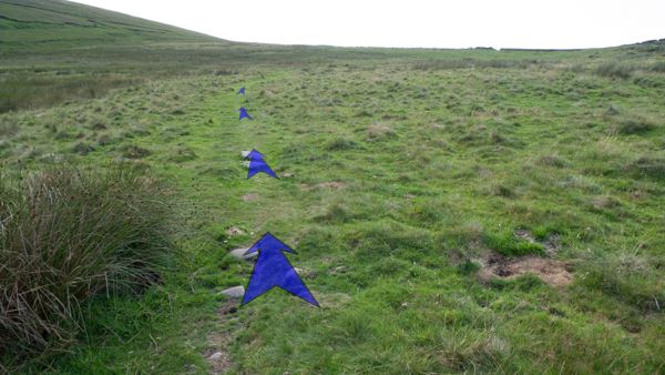 A photo of step 1 of the Three Shires Head route, with blue arrows superimposed to show the way.