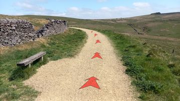 A photo of step 3 of the Wildmoorstone Valley Walk route, with red arrows superimposed to show the way.
