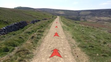 A photo of step 5 of the Wildmoorstone Valley Walk route, with red arrows superimposed to show the way.