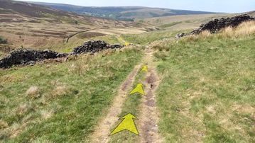 A photo of step 7 of the Wildmoorstone Valley Walk route, with yellow arrows superimposed to show the way.
